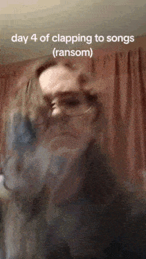 a woman wearing glasses is clapping to a song with the caption day 4 of clapping to songs ( ransom )