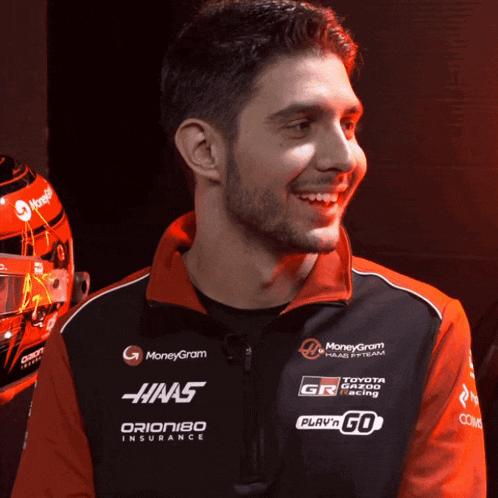 a man wearing a jacket that says haas orion180 insurance