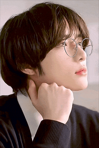 a close up of a person wearing glasses and a black shirt