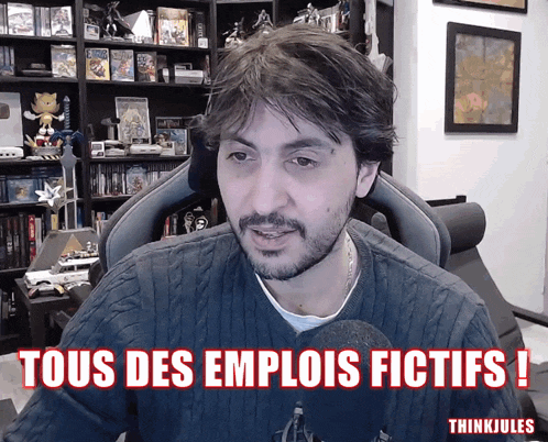 a man sitting in front of a microphone with the words " tous des emplois fictifs " on the screen