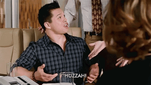 a man in a plaid shirt says huzzah in front of a glass