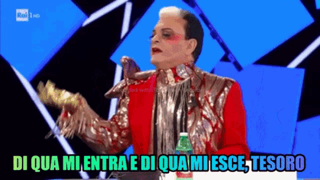 a man in a red jacket is holding a green bottle with the words di qua mi entra e di qua mi esce tesoro below him