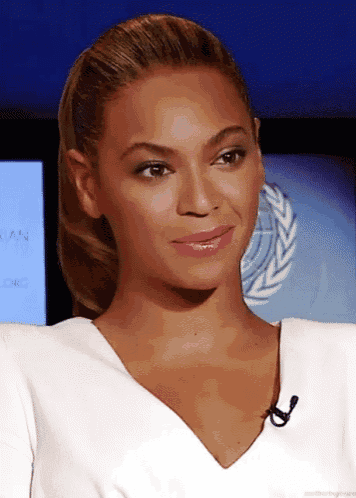 a woman wearing a white shirt with a microphone in front of a screen that says ' ian ' on it