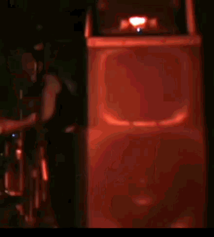 a blurred image of a speaker with a red light shining on it