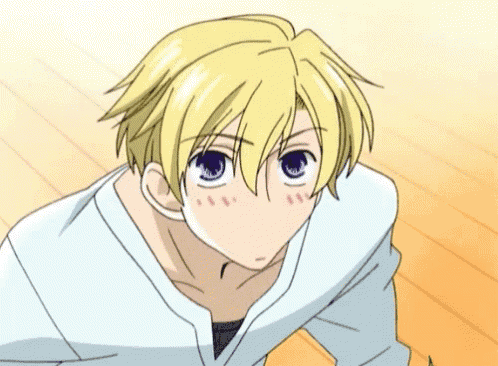 a boy with blonde hair and purple eyes is making a funny face with his mouth open .