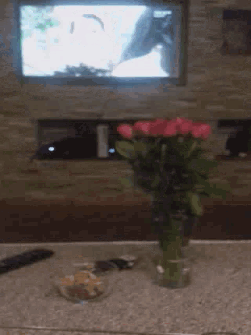 a bunch of roses are in a vase on a counter .