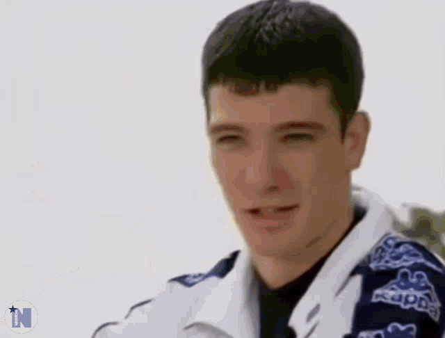 a man wearing a kappa jacket is smiling