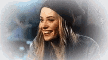 a woman wearing a black beanie and smiling