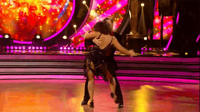 a man and woman are dancing on a dance floor .