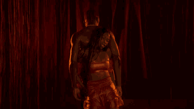a woman in a red dress is dancing with a man