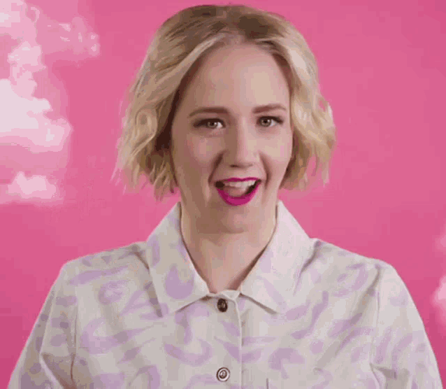 a woman wearing a purple and white shirt with a yellow square with a hashtag on it