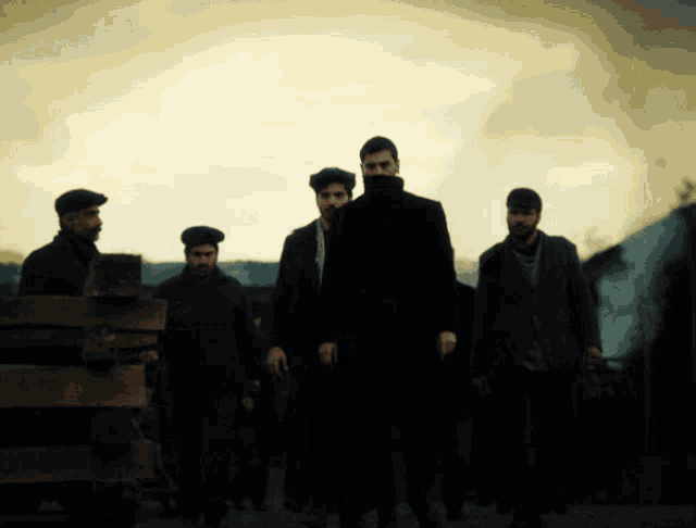 a group of men in suits and hats are standing in a dark room