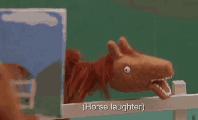 a stuffed horse behind a fence with the words horse laughter written below it