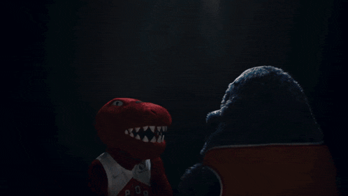 a raptors mascot is standing next to a blue monster