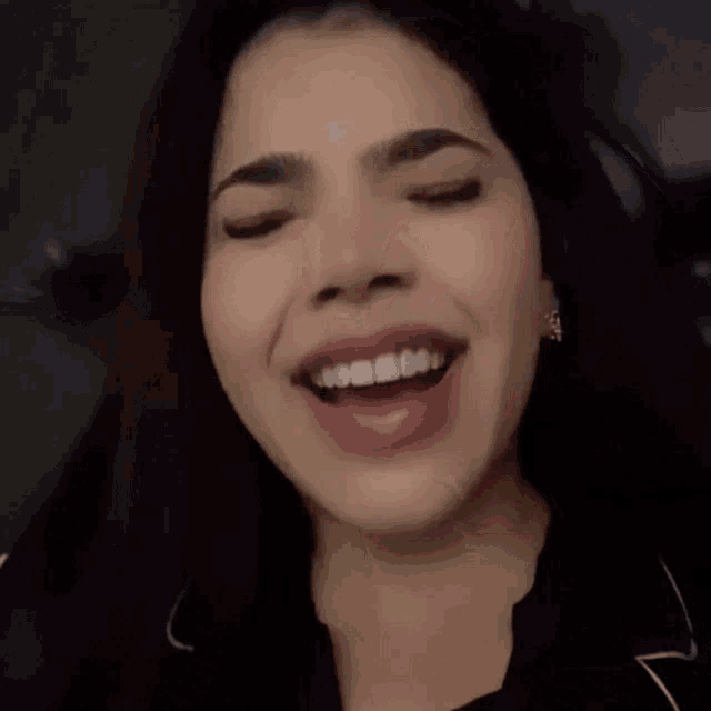 a close up of a woman 's face with her mouth open and her eyes closed .