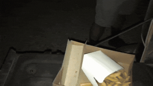 a box of french fries sits on top of a pile of paper bags