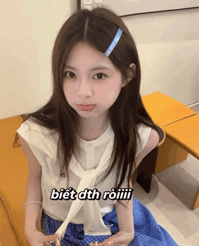 a girl wearing a white shirt and a blue plaid skirt with the words biết dth roiiii on the bottom right