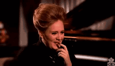 a woman is sitting in front of a piano with her hand on her chin .
