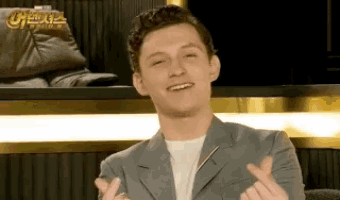 a man in a suit is making a heart with his fingers