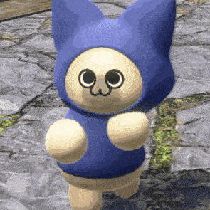 a stuffed animal wearing a blue cat costume is standing on a rocky surface