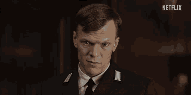 a man in a suit and tie is looking at the camera with a netflix logo behind him