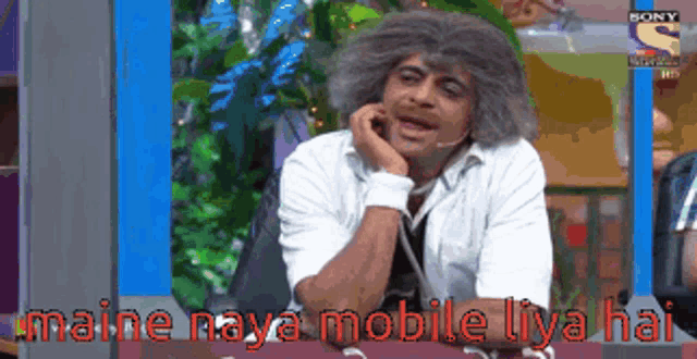a man with gray hair is talking on a phone with the words maine naya mobile lya hai below him