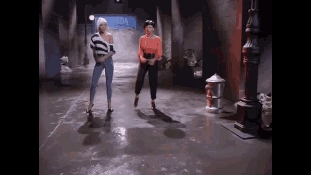 two women are dancing in front of a sign that says olympics
