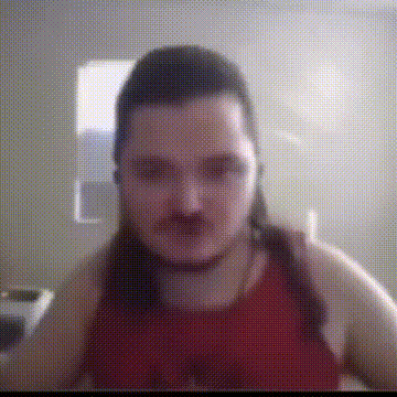 a man with long hair and a mustache is wearing a red shirt .