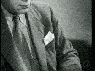 a man in a suit and tie has a piece of paper in his pocket