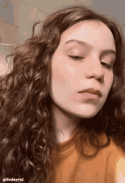 a close up of a woman 's face with the words gifsdayrol on the bottom right