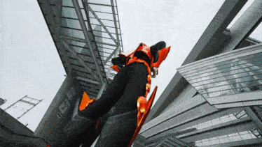 a person in an orange and black costume stands in front of a building