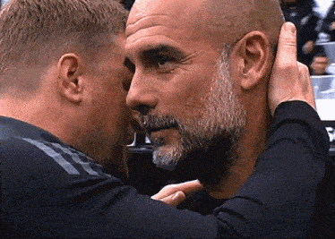 two men are touching each other 's faces and one has a beard