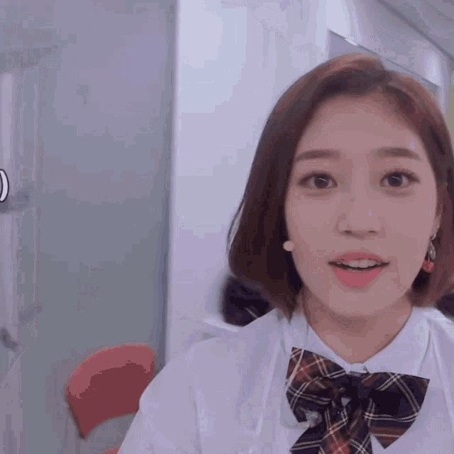 a girl with short hair and a plaid bow tie