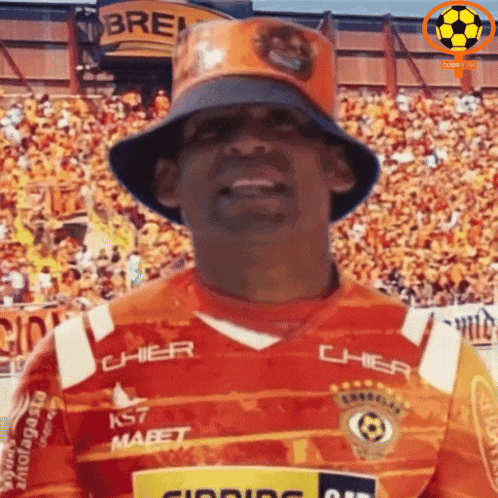 a man wearing a bucket hat and an orange shirt that says cher