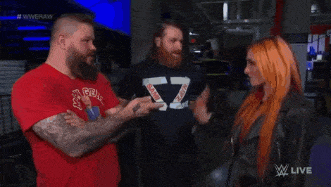 a group of wrestlers are standing next to each other in a room .