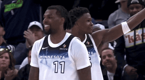 two basketball players from the minnesota team are smiling