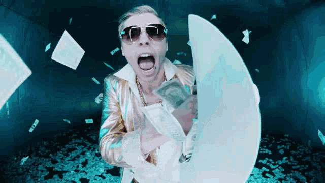 a man wearing sunglasses is holding a bunch of money in his hands