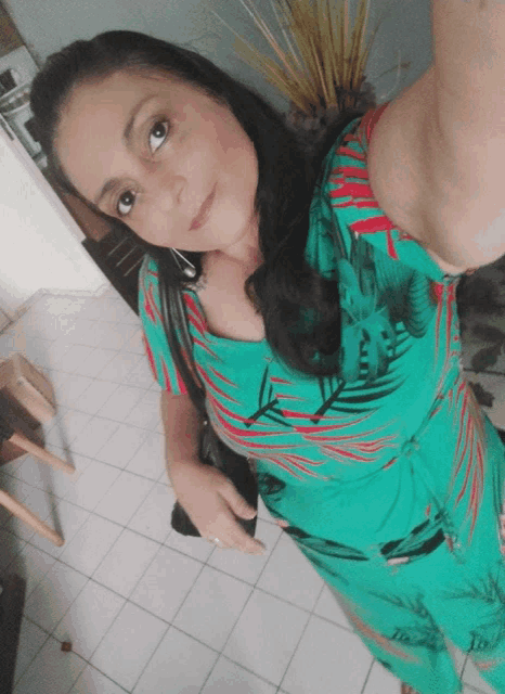 a woman in a green dress takes a selfie