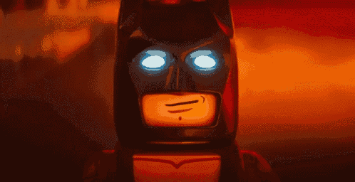 a close up of a lego batman 's face with blue eyes