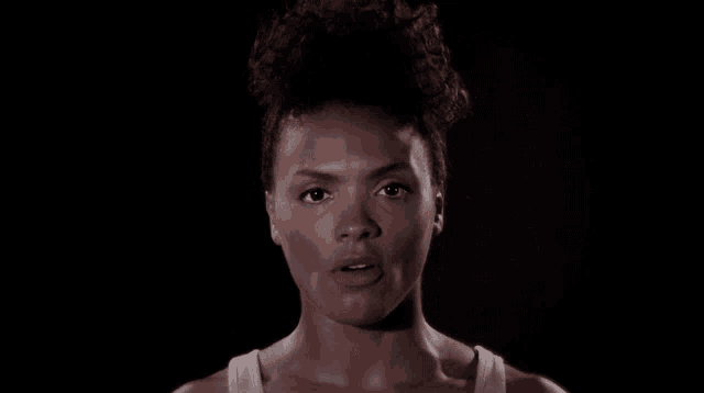 a close up of a woman 's face with a dark background
