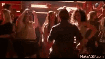 a man is dancing in front of a crowd of people at a party .