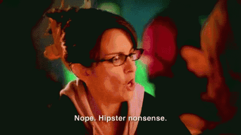 a woman wearing glasses is talking to another woman in a dark room .