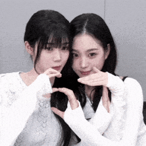 two girls making a heart with their hands