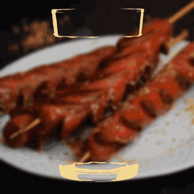 a white plate topped with skewers of meat with a yellow border around it