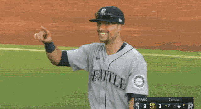 a baseball player for the seattle mariners is pointing at something