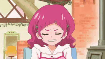 a cartoon girl with pink hair is sitting on a couch .
