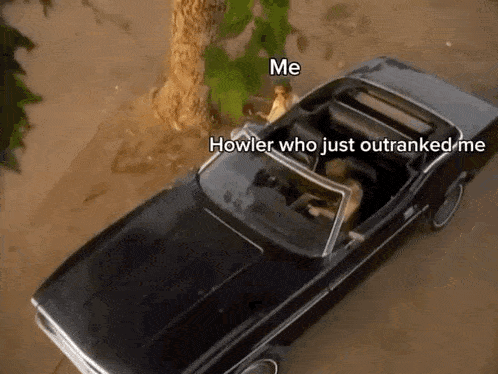 a man is sitting in a black convertible car with the words `` hower who just outranked me '' written on it .