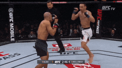 two men are fighting in a boxing ring with ufc mobile written on the side