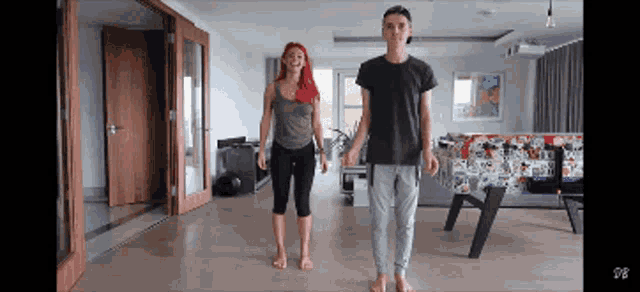 a man and a woman are standing next to each other in a living room ..
