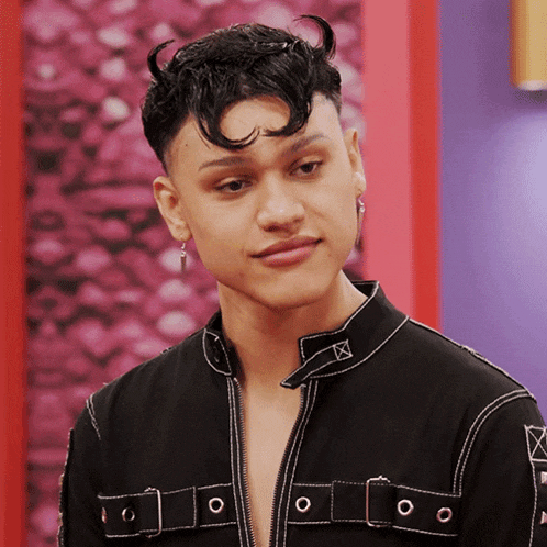 a young man with horns on his head is wearing a black jacket and earrings